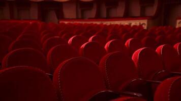Red chairs background. Rows of comfortable chairs without people in a theatrical hall. Empty auditorium with red velvet seats. Close-up. video