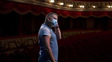 Actor in medical mask on theatre scene. Man rehearsing on stage and taking off protective mask while leading monologue. Pandemic in the world. video