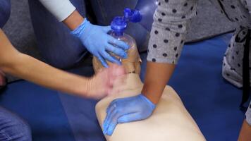Giving first aid on a mannequin. Students teaching to do cardiopulmonology procedure on a dummy in training center. Practical skills for saving people. Top view. video