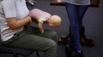 Practical course on a doll dummy. Female practitioner teaching to reanimate patient on a baby mannequine. Instructor demonstrate the training exercise. video