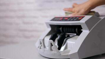 Bank automatic equipment for calculation paper currency. Currency counting machine counting dollar bills. Female worker taking out a bundle of one hundred usd from automatic machine. Side view. video