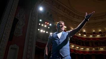 Man on stage gesticulating and talk. Professional actor performing his role on spotlight background in theater. View from stage. video