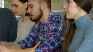 Focused students diligently taking notes during a lecture video