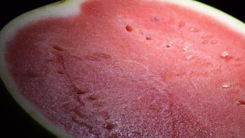 Watermelon red fruit gyrating on black background video