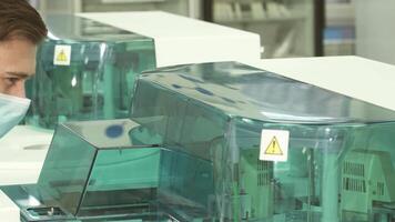 Focused laboratory assistant intently observes the centrifuge in action video
