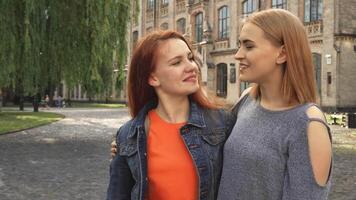Two girls joyfully laughing and embracing each other video