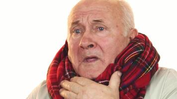 Tired senior man in a vibrant scarf coughing and looking away video