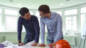 Two architects collaborate on a building project in a modern office video