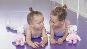 Two little ballerinas resting on the floor, sharing secrets after ballet practice video