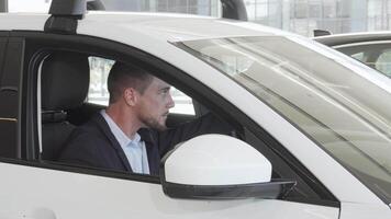 Joyful man exploring the sleek interior of a new car video