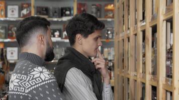 Two young men exploring a vibrant wine market video