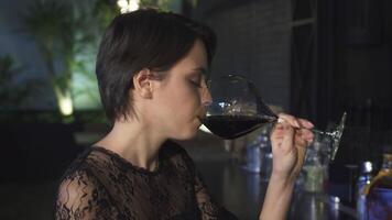 Enchanting brunette woman savoring wine at a chic bar video