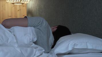 Comfortable sleeping environment highlighting female resting peacefully, smoothly changing positions while lying in soft bedding during nighttime hours, representing quality sleep and wellness video