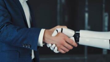 Businessman in blue suit shaking hands with humanoid robot in a modern tech setting, symbolizing cooperation, artificial intelligence, futuristic and partnership between humans and video