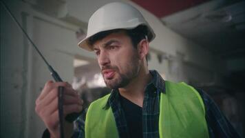 Furious irritated Caucasian workman architect foreman talking walkie talkie guy handyman inspector shouting man argument in construction male control manufacture builder screaming dissatisfaction work video