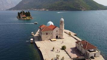 Drone view of the island with the church of our lady of the rocks centered in the image. Tourist attraction in summer near Perast in the Bay of Kotor, Montenegro video