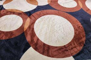Background of fabric motif with large circle pattern in brown, cream photo
