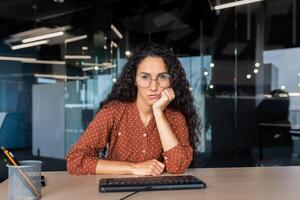 call, a dissatisfied call center employee listens to the interlocutor, a Latin American woman does not understand the user of the support service, does not know what to answer. photo