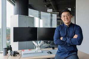 Portrait of successful programmer in modern office of development company, asian man with crossed arms smiling and looking at camera. photo