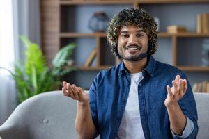 Smiling man hosting a virtual meeting with headset in modern home office photo