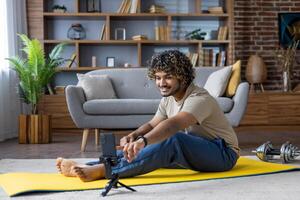 Man engaging in home workout while filming with smartphone on exercise mat photo