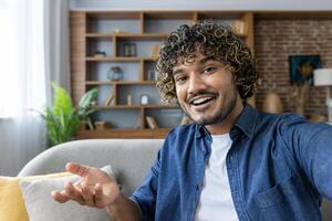 Smiling man taking a selfie in modern living room setting photo