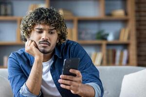 Man looking at smartphone with expression of concern and curiosity on his face photo