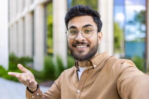 Smiling man taking selfie in outdoor setting near office building photo
