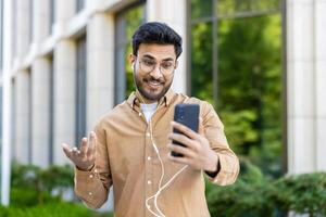Man using smartphone for call outside modern office building photo