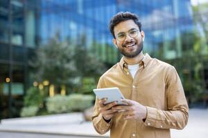 Confident young man using digital tablet in modern urban setting photo