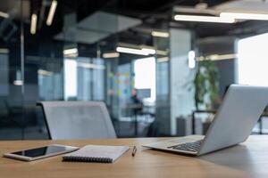 Modern office desk setup with laptop, smartphone, and notebook in sleek environment photo