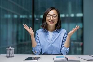 Webcam view, joyful Asian woman looking into the camera, smiling contentedly talking to colleagues and partners using call, and remotely conferencing online. photo