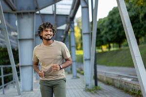 Young man running and doing active physical exercises, dressed in sporty casual clothes. photo