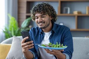 A man uses a phone app to determine the calorie content of his salad. He smiles while analyzing the food photo