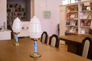 Vintage lamps on a table in a traditional public library with bookshelfs photo