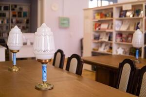 Vintage lamps on table in a traditional public library with bookshelfs photo