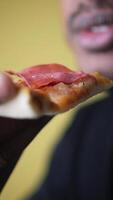 Enjoying savory pizza slice with ham close-up video