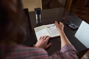 Man Writing Notes at Desk for Business Planning or Project Organization photo