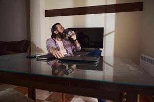 Man Relaxing at Home While Drinking Coffee by the Table photo