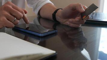 Man Using Smartphone and Credit Card for Online Payment in Office photo
