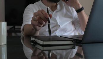 Focused Professional Using Laptop and Notebook in Home Office Setting photo