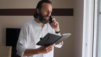 Professional Man Working with Notebook and Phone in Bright Office Environment photo