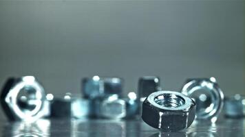 The nut is spinning on a metal table. Filmed on a high-speed camera at 1000 fps. High quality FullHD footage video