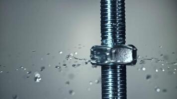 The nut is twisted on the thread of the bolt. Filmed on a high-speed camera at 1000 fps. High quality FullHD footage video