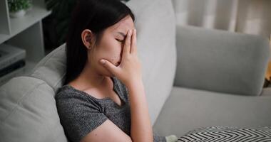 Handheld high angle view shot, Stressed woman sits alone on a sofa, thinking aimlessly, feeling worried about something. Life problems video