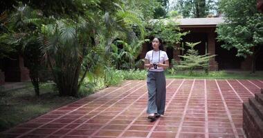 Woman tourist enjoys taking photos with camera while taking a leisurely stroll amidst serene surroundings and the cultural richness of the place. video