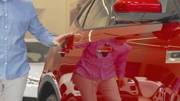 Man exploring a sleek new automobile at a vibrant car dealership video
