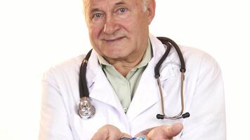 Senior doctor presenting a vibrant array of colorful pills to the camera video