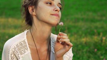 Joyful girl enjoying the scent of a flower in a serene outdoor setting video