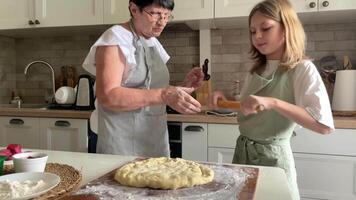 Grandmother and grandchild preparing pizza dough video